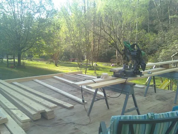 Miter saw and framing lumber on a deck under construction in Princeville