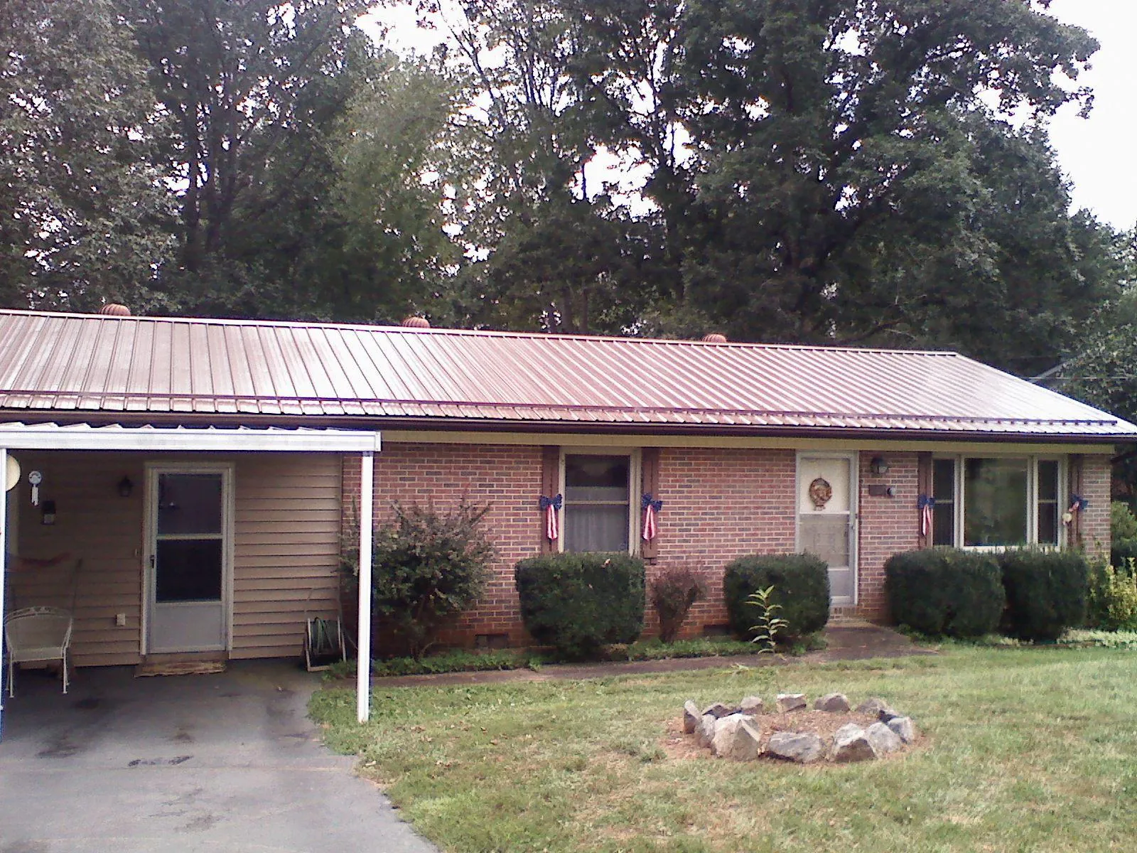 Bronze metal roof and carport on a brick ranch home — Roof Repair work by our crew in Princeville